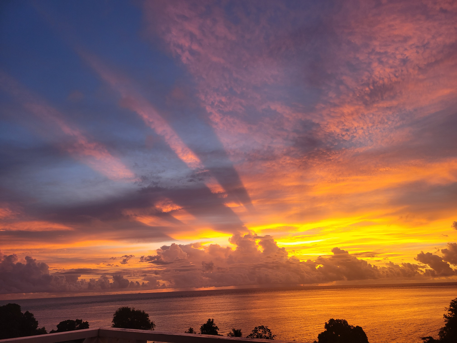 Dramatic sunset sky in purple, gold, and ember tones over the sea