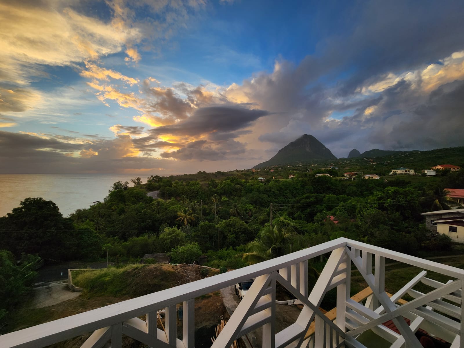 Sunset sky over the ocean and hills seen from the villa balcony
